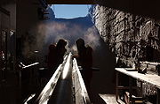 Deux hommes dans une fosse préparant un long tube métallique reposant sur une gouttière